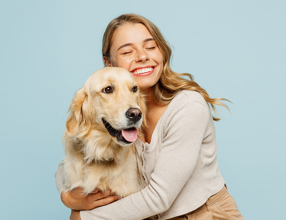 Happy young woman cuddling her dog